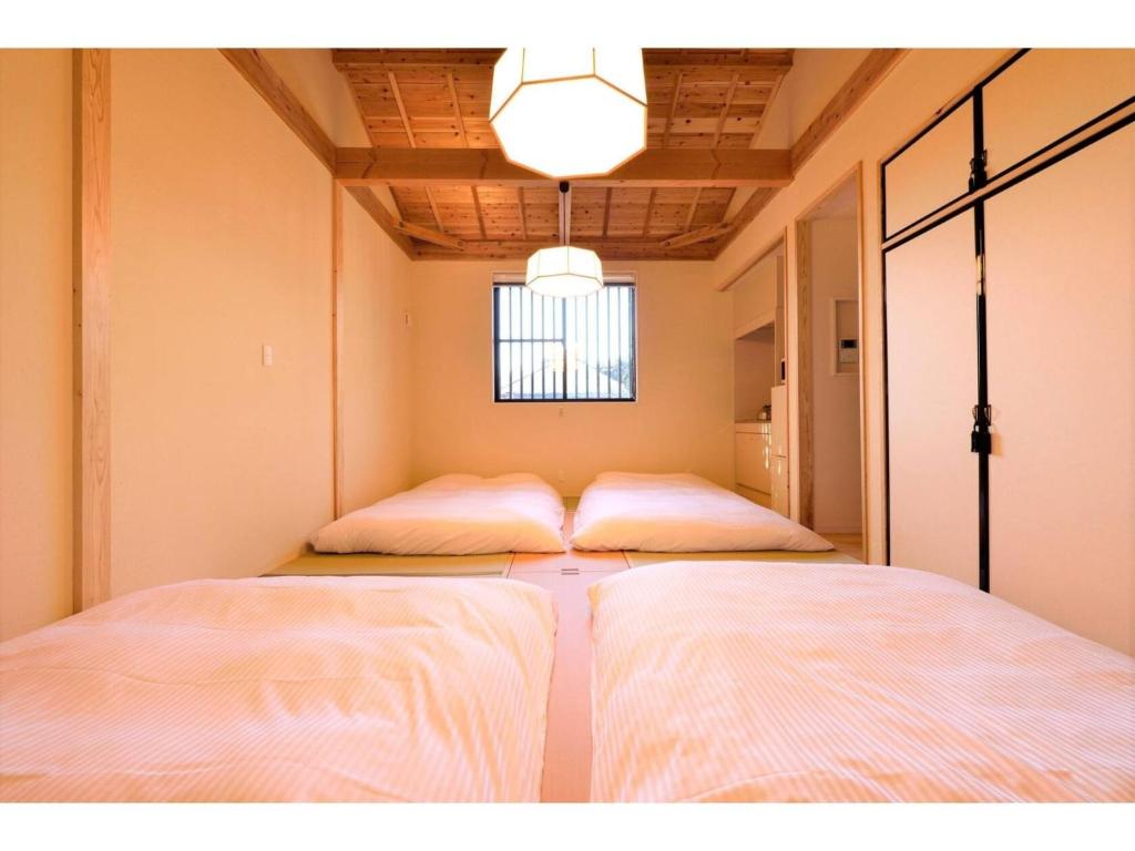 Cette chambre comprend 2 lits et une fenêtre. dans l'établissement Hinata-an Botan - Vacation STAY 86855, à Yufu