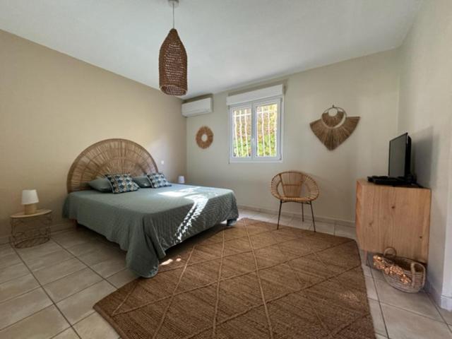 1 dormitorio con 1 cama y TV en Anse des Caraïbes en Les Trois-Îlets