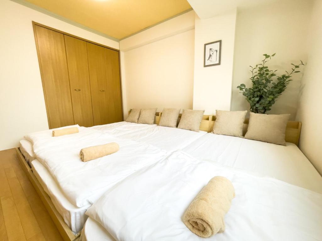大阪的住宿－TasoneUrbanStayOsaka なんば日本橋三陽グリーンハイツ203，一张白色的大床,带两条毛巾