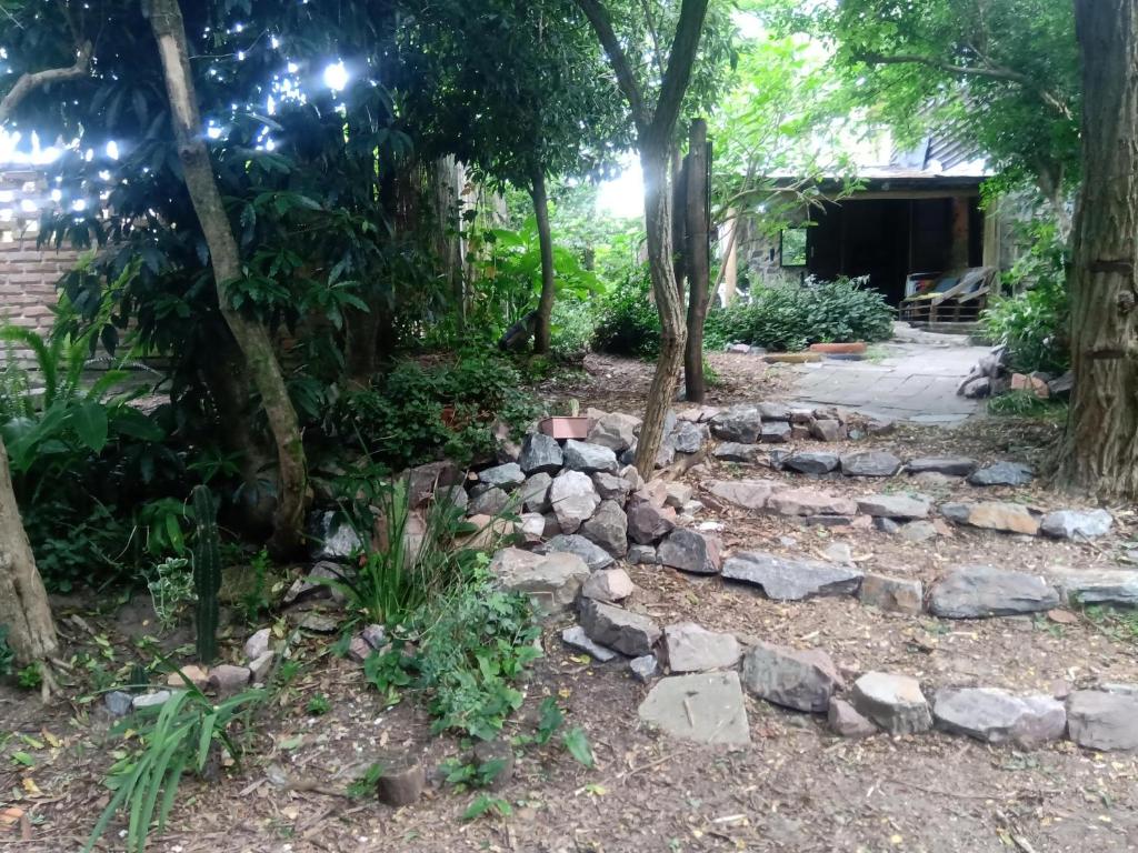 a garden with rocks and trees in front of a house at Casa Marindia una cuadra playa in Salinas 