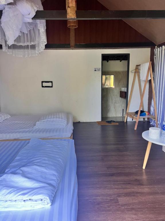 a bedroom with a bed and a wooden floor at Komleo Farm in Buôn Kô M'lêo