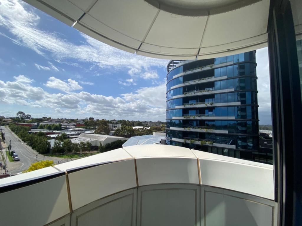 een balkon met uitzicht op een hoog blauw gebouw bij Galleria Deluxe & Spacious apartment + Shopping Centre & Train in Glen Waverley