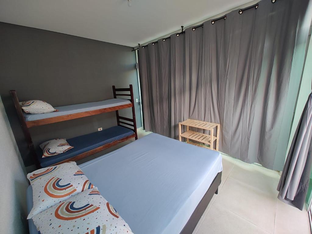 a small bedroom with a bed and a bunk bed at HOSTEL FAMÍLIA CASTOR in Itanhaém