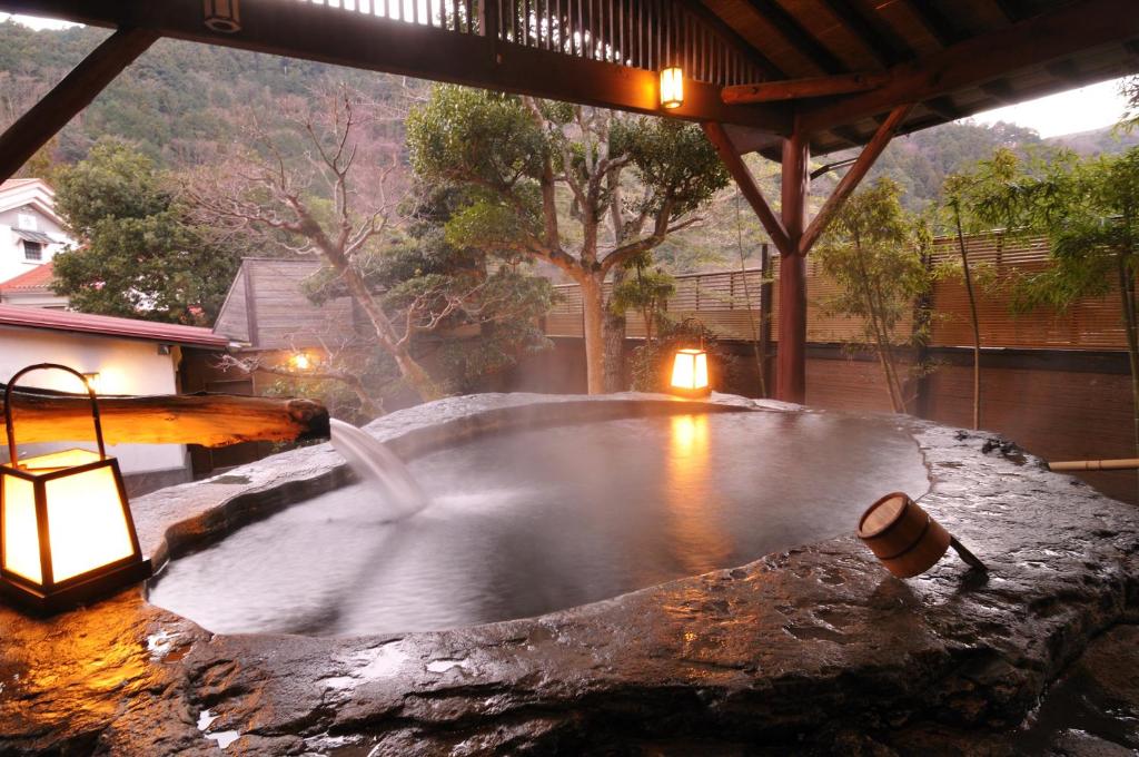 a hot tub in the middle of a house at Shirakabeso in Izu