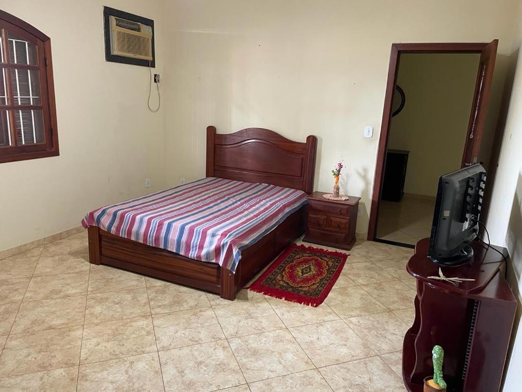 a bedroom with a bed and a tv and a mirror at Casa em Saquarema in Saquarema