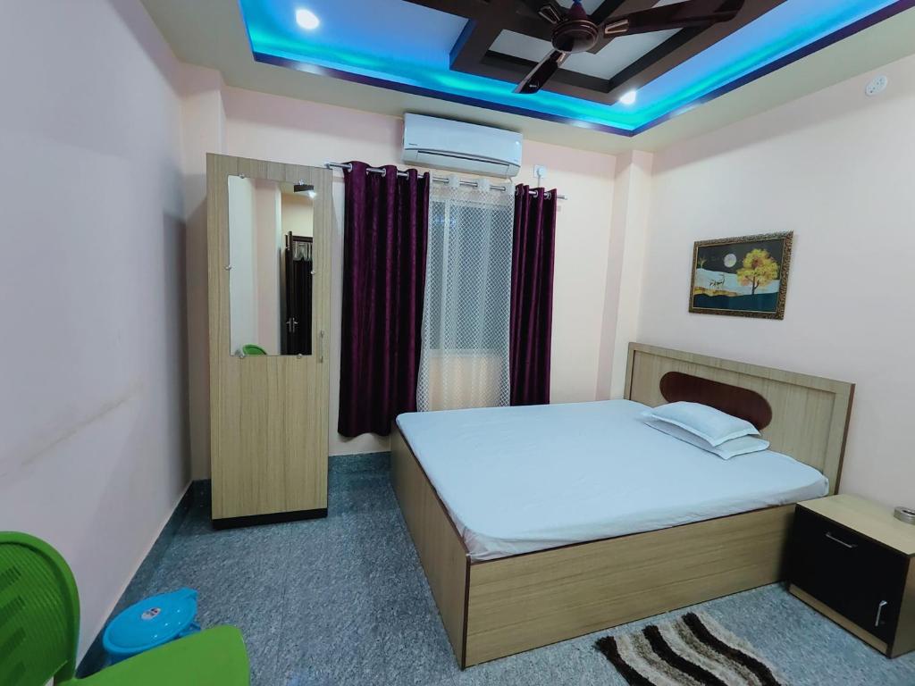 a bedroom with a bed and a blue light at GULAB LODGE in Siliguri