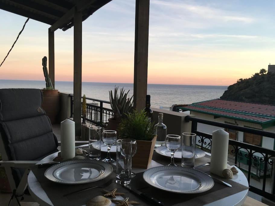 tavolo con bicchieri da vino e vista sull'oceano di Amazing Beachside Apartment With Panoramic Seaview a Paránimfoi