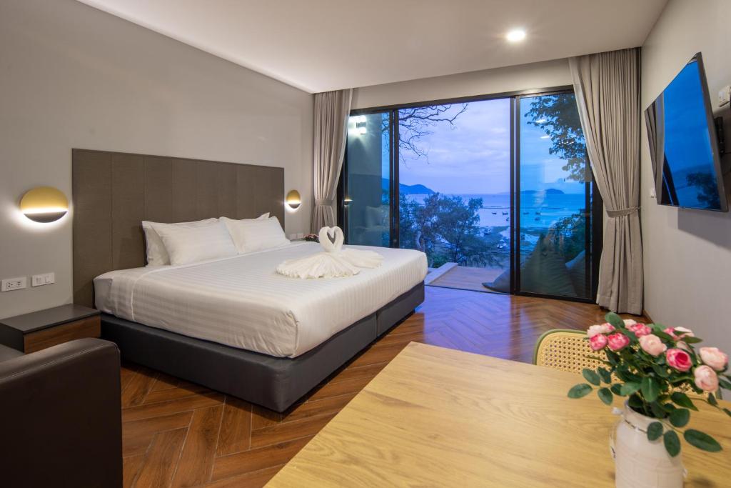 ナイハーンビーチにあるNature Vista Rawaiのベッドと大きな窓が備わるホテルルームです。
