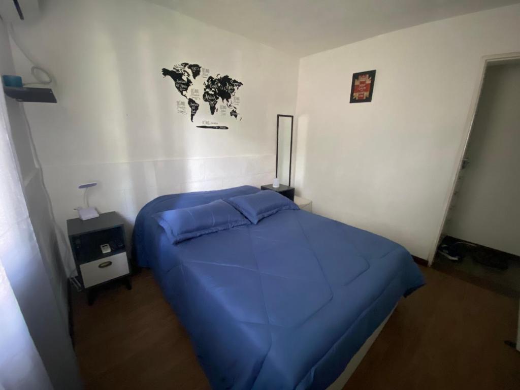 Un dormitorio con una cama azul con un mapa en la pared en Lindo apto Mvd shopping puerto de buceo/pocitos, en Montevideo