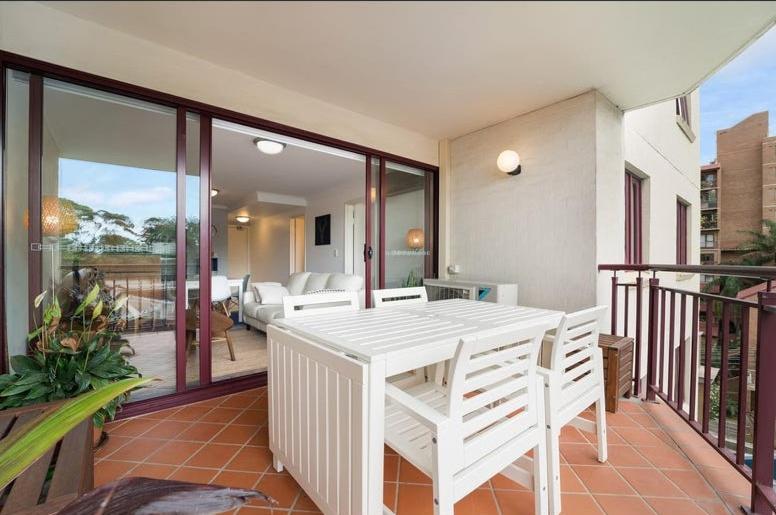 a patio with a white table and chairs on a balcony at Entire Apartment in Surry Hills in Sydney