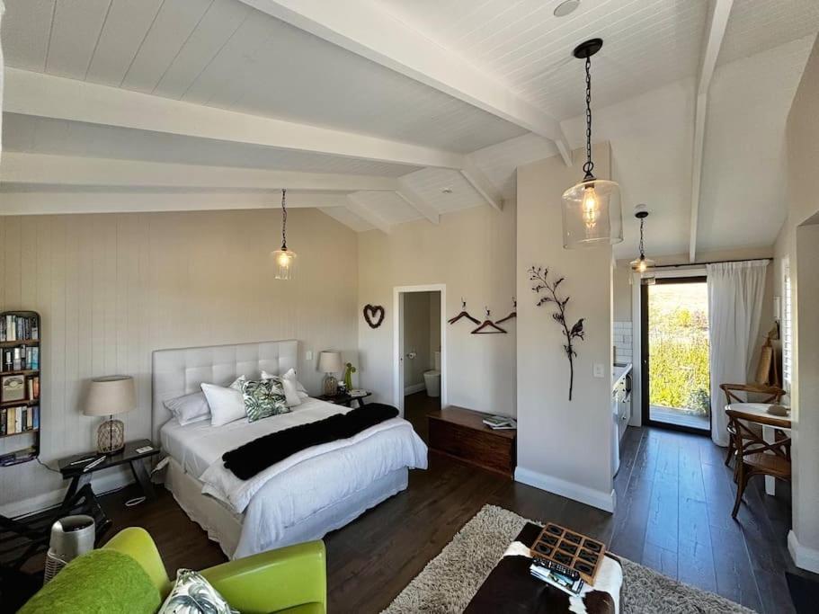 a bedroom with a bed and a living room at Luxury cottage with stunning vineyard views in Renwick
