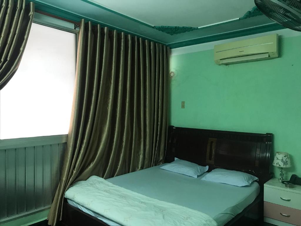 Khách Sạn Xuân Quang في كان ثو: غرفة نوم صغيرة بها سرير ونافذة