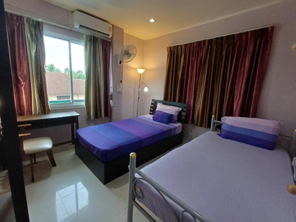 a bedroom with two beds and a desk and a window at 168Hostel Airport@Phuket in Thalang