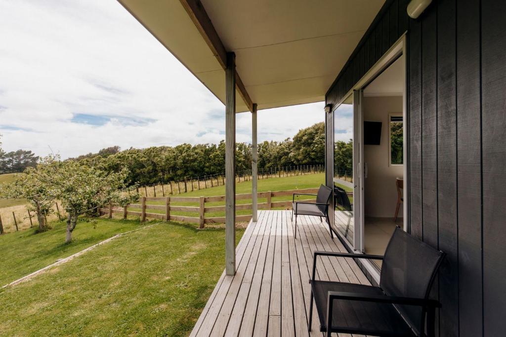 een veranda met stoelen en uitzicht op een veld bij Dorset Retreat in Hillsborough