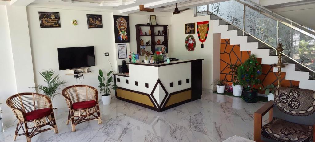 sala de estar con TV y escalera en White House Residency, en Varkala