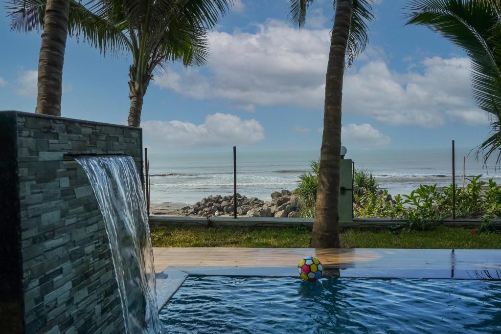 - une piscine avec une cascade et une plage dans l'établissement En Ocean Infinity Pool Villa Overlooking Sea ,Beach Touch, à Alibaug