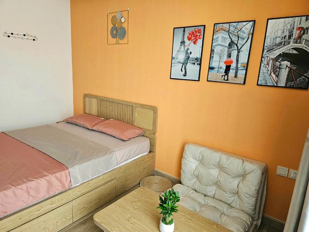 a bedroom with a bed and a chair and pictures on the wall at Mây Homestay in Hanoi
