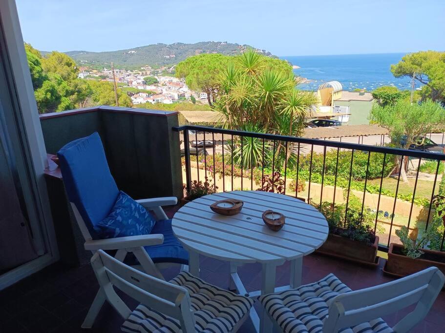 een tafel en stoelen op een balkon met uitzicht op de oceaan bij Apartamento estilo marinero en Calella Palafrugell in Palafrugell
