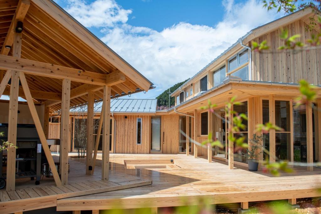 een houten huis met een groot terras bij 木を楽しむ一棟貸しの宿「ウッドヴィラ 心楽 -SHIGURA-」 in Tamba