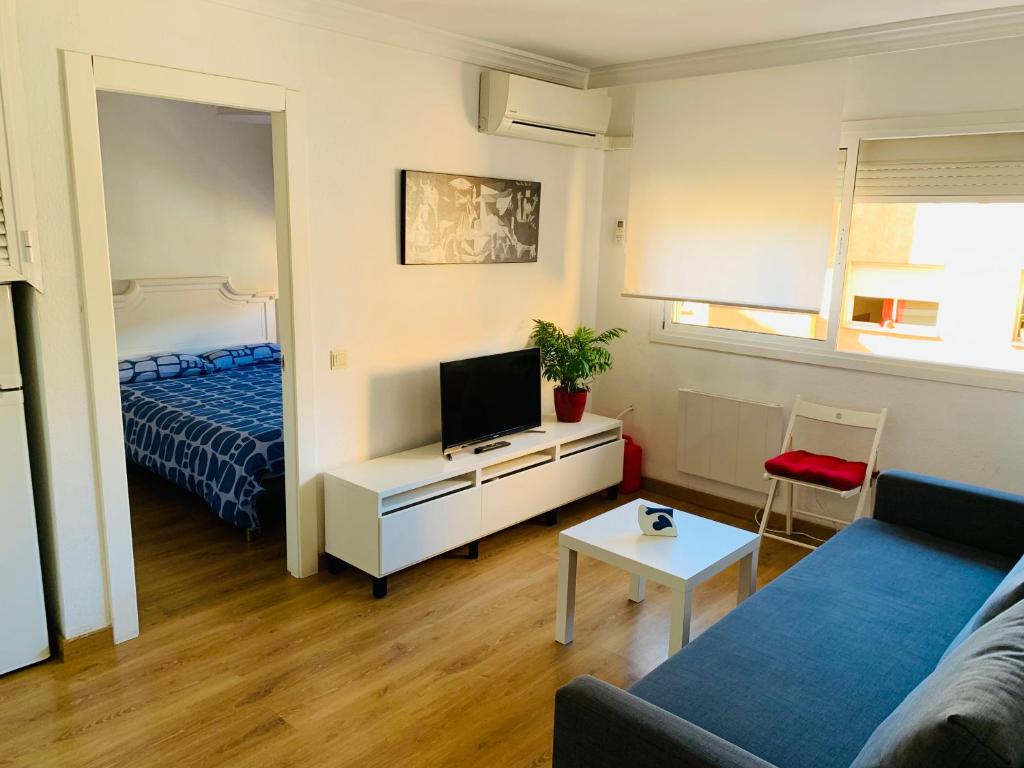una pequeña sala de estar con cama y TV en Ana's Apartment parking gratuito en Málaga