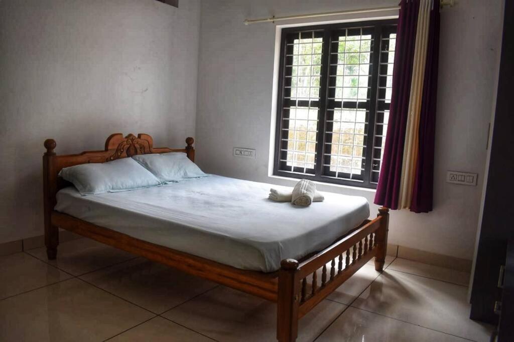 un letto con un orsacchiotto che si siede su di esso in una camera da letto di Home with garden in a serene locality a Wayanad