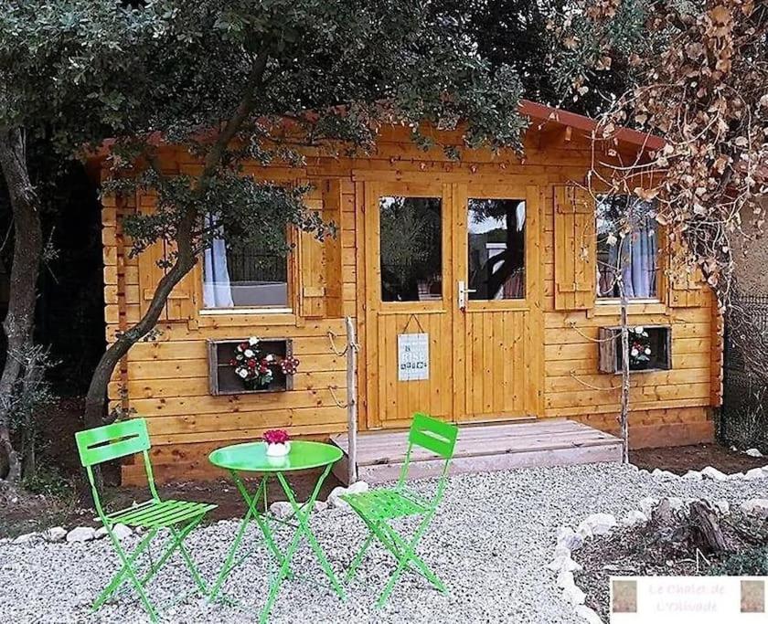 eine Hütte mit einem Tisch und Stühlen davor in der Unterkunft le chalet sous l'olivier in Boulbon