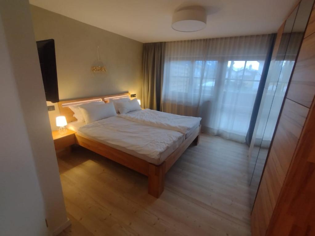 een kleine slaapkamer met een bed en een raam bij Ferienwohnung Bergzauber Krün in Krün