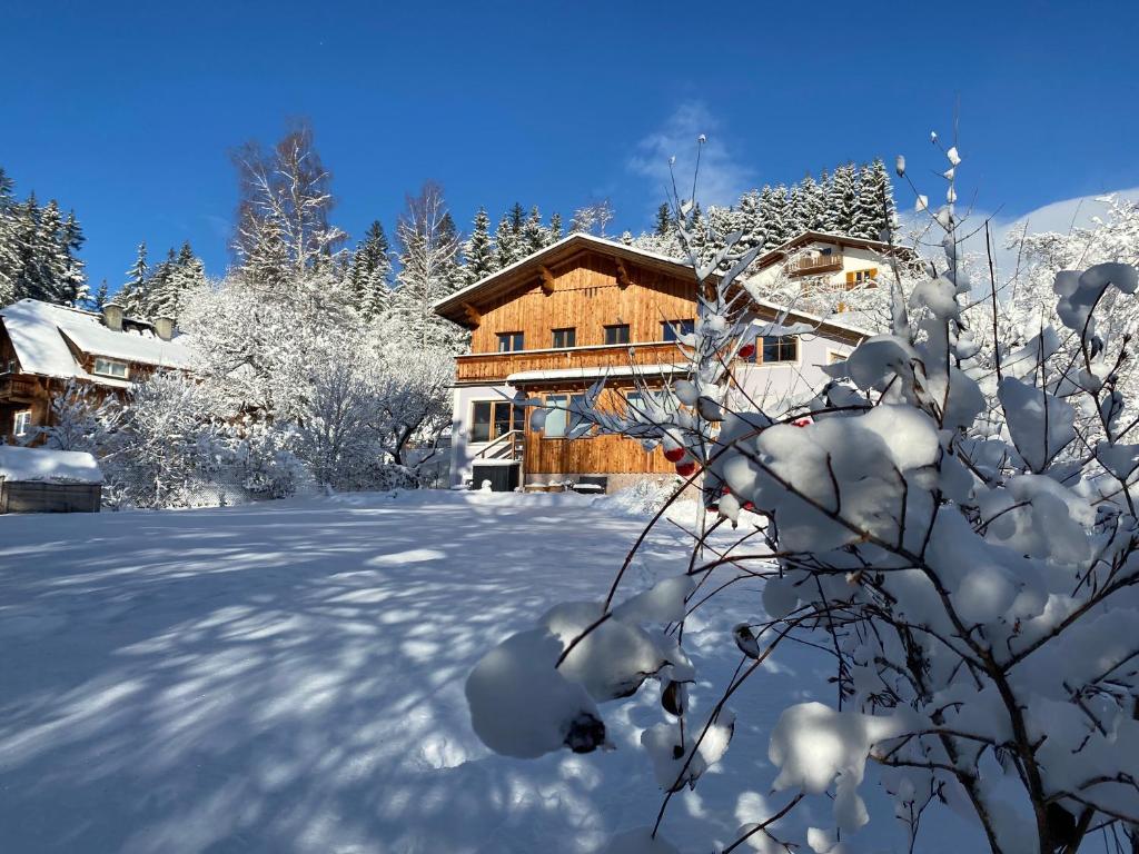een blokhut in de sneeuw met sneeuw bedekte bomen bij Villa Hansalhof, Wohnung Rosenduft in Mariapfarr