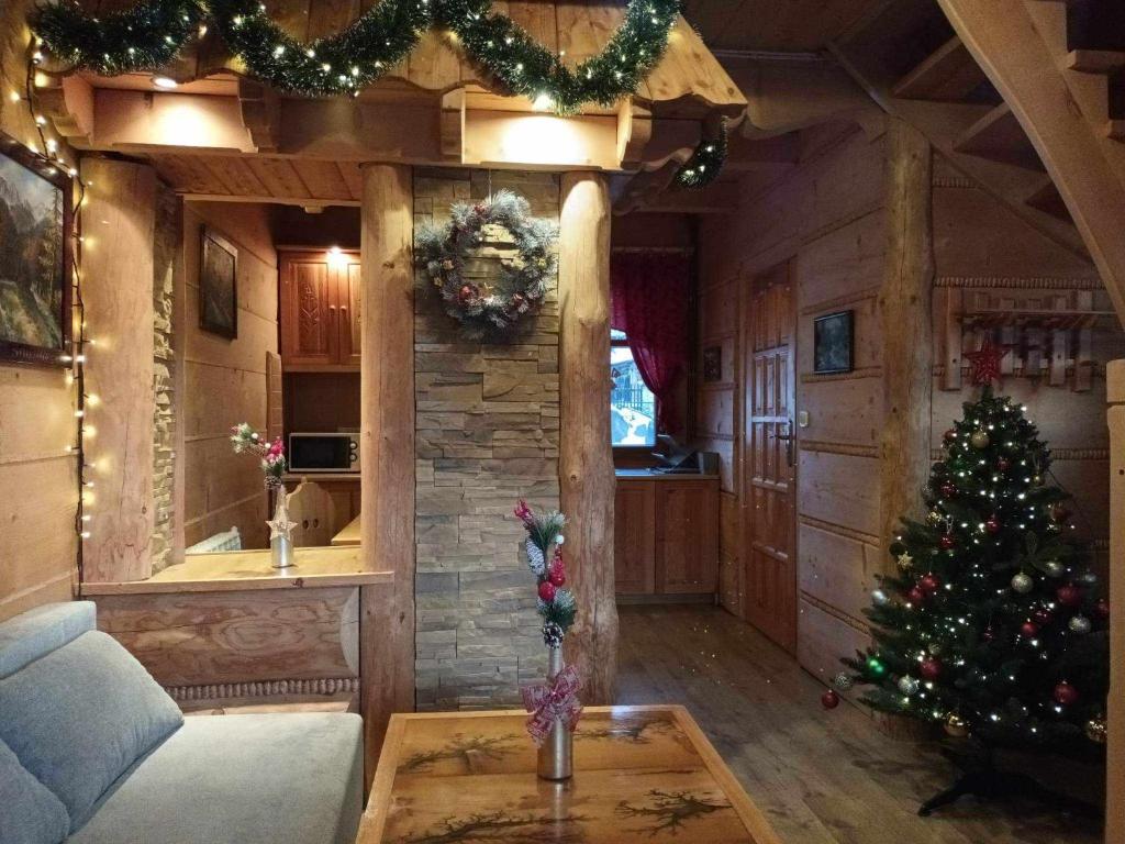 Szałas u Szpunara في كوشتيليسكا: غرفة معيشة مع شجرة عيد الميلاد في منزل