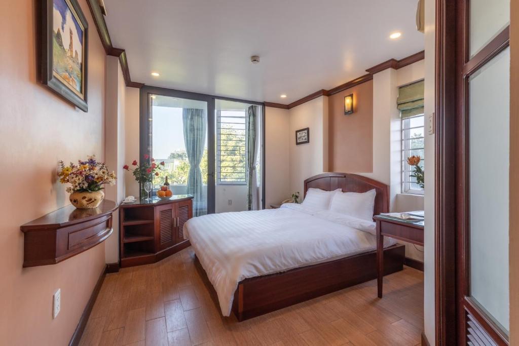 sypialnia z łóżkiem, biurkiem i oknem w obiekcie T - Apartment w mieście Hanoi