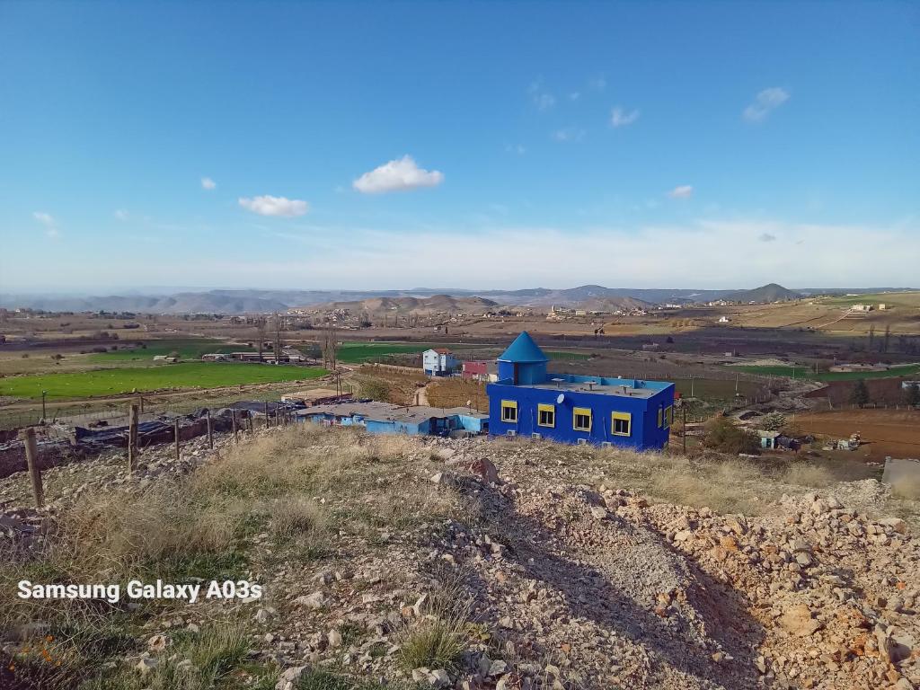 un bâtiment bleu sur le côté d'une colline dans l'établissement Gîte Forest Tagroumte, à Azrou