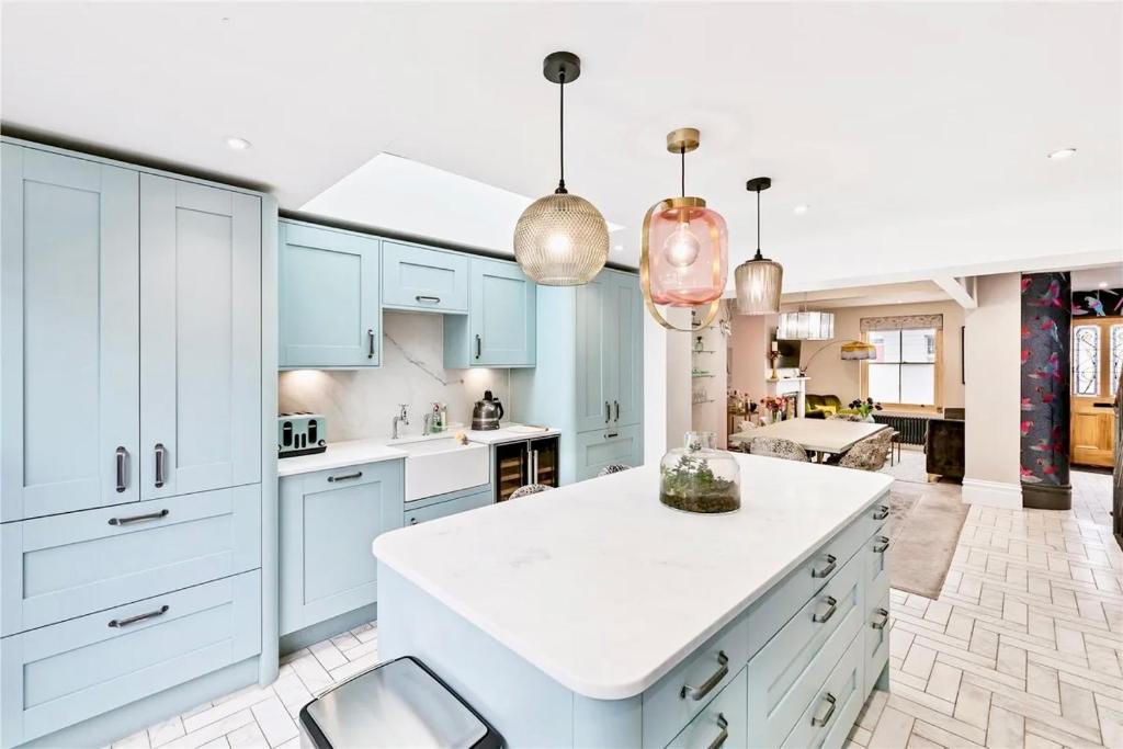 a kitchen with blue cabinets and a white island at Stylish, Central, North Laine, Newly Decorated in Brighton & Hove