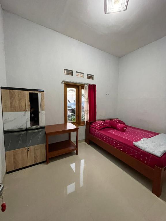 um quarto com uma cama e uma mesa em Villa Cakrawala em Tawangmangu