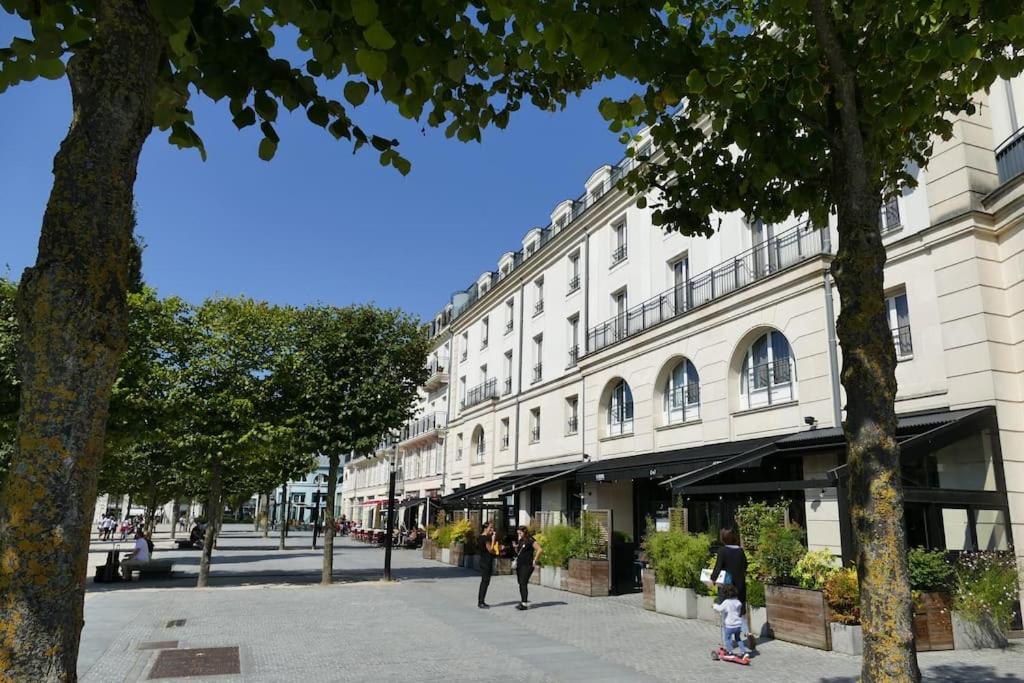 a large white building with people walking in front of it at Disneyland Paris 70m² face Parc, place Ariane in Serris