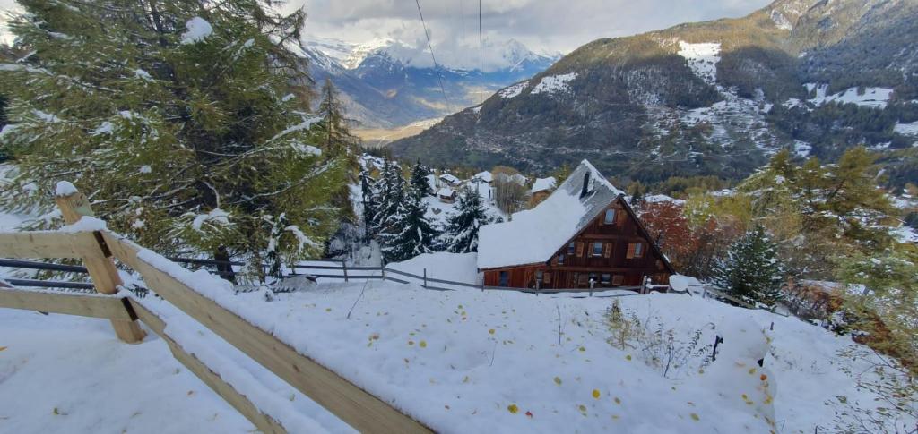una baita in montagna con la neve sopra di Chalet Les Portes a Riddes