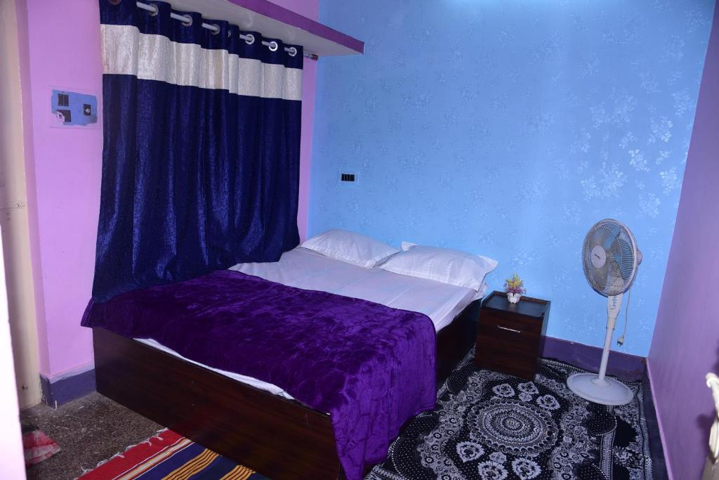 a bedroom with a purple bed and a blue wall at S & H Stay Home in Mysore