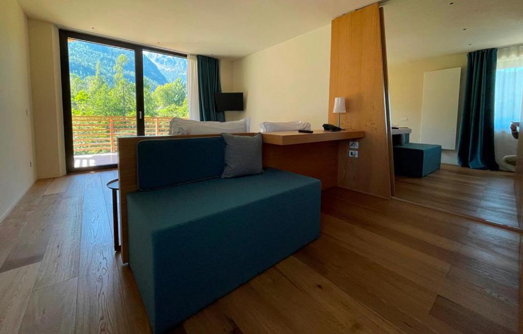 a living room with a blue couch and a desk at Mont Avic Resort & Wellness in Champdepraz