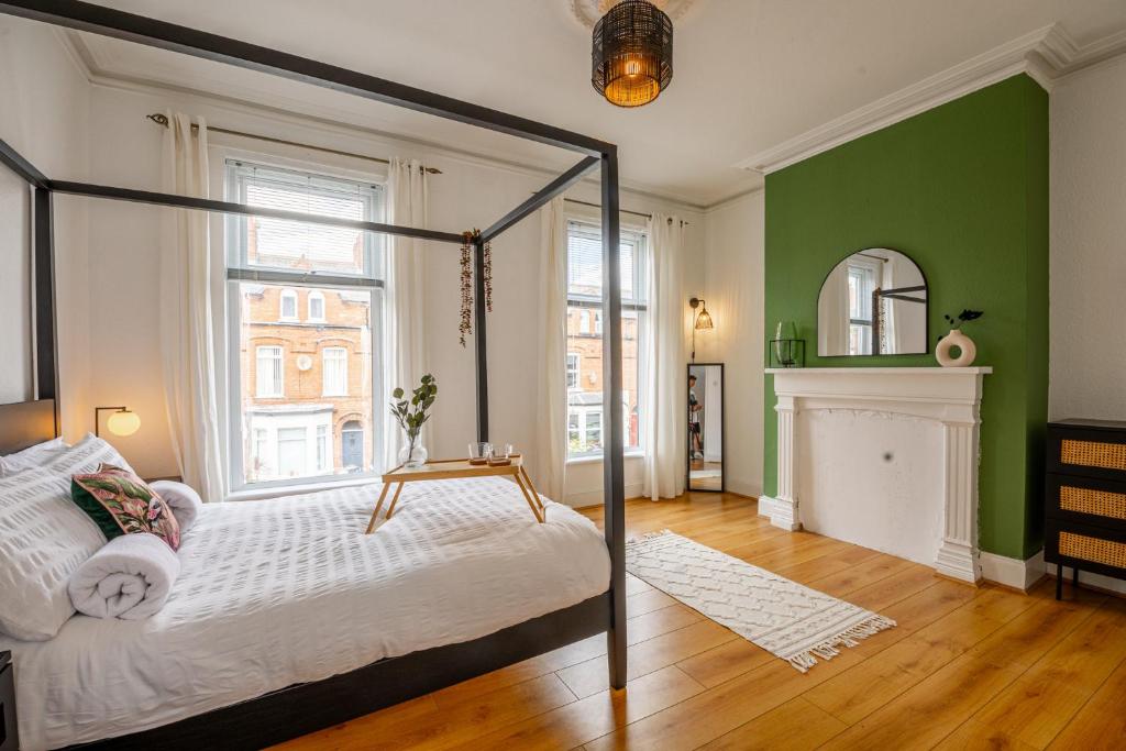 1 dormitorio con cama con dosel y chimenea en Loving Victorian Home For Your Belfast Escape!, en Belfast