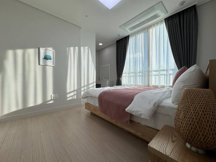 a bedroom with a bed and a large window at Eunhasu D&M Residence Cheongcho 4 in Daejeon