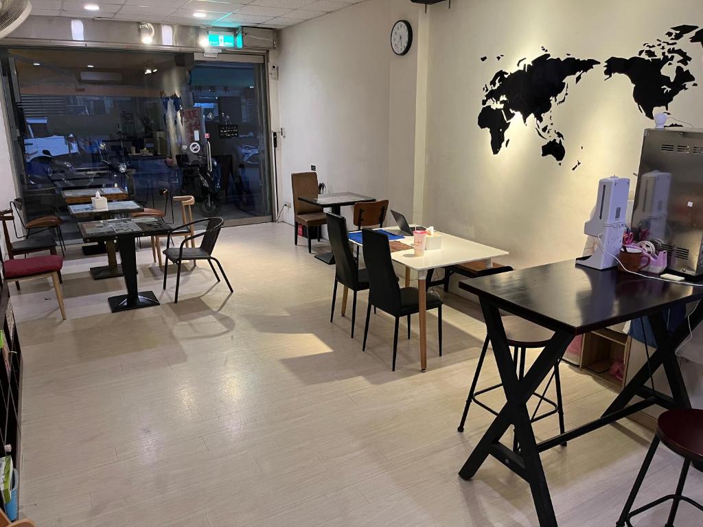 a restaurant with tables and chairs and a world on the wall at Little House in Chiayi City