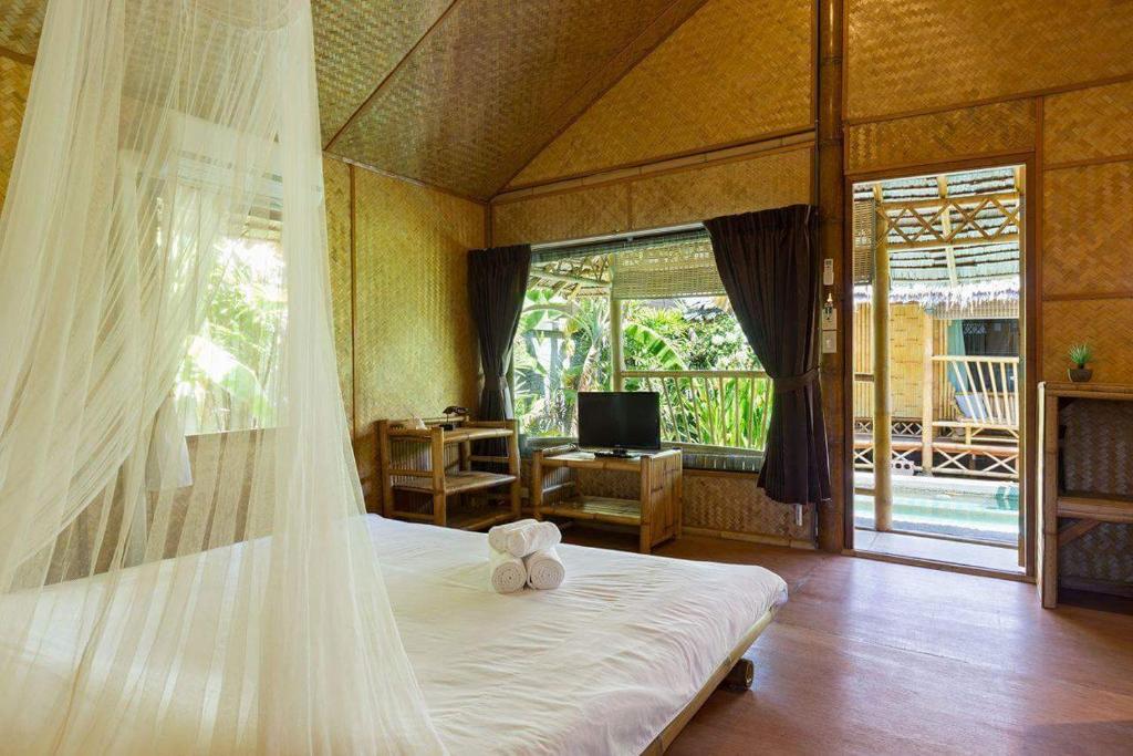 a bedroom with a bed with a teddy bear on it at Bamboo Heaven Home in Rawai Beach