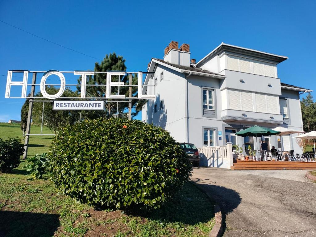 a house with a sign in front of it at Hotel Capellan in Navia