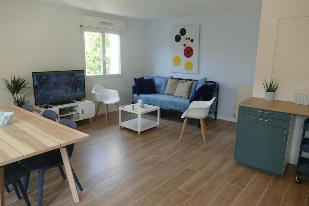 a living room with a blue couch and a tv at Disneyland Paris, appartement 70m², parking privé in Serris