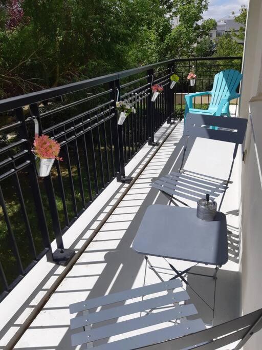 two chairs and a table on a balcony at Disneyland Paris, appartement 70m², parking privé in Serris