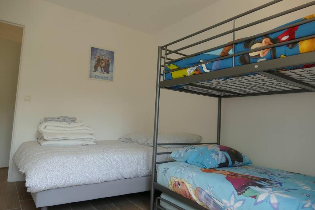 a bedroom with a bunk bed next to a bunk bed gmaxwell gmaxwell gmaxwell at Disneyland Paris, appartement 70m², parking privé in Serris