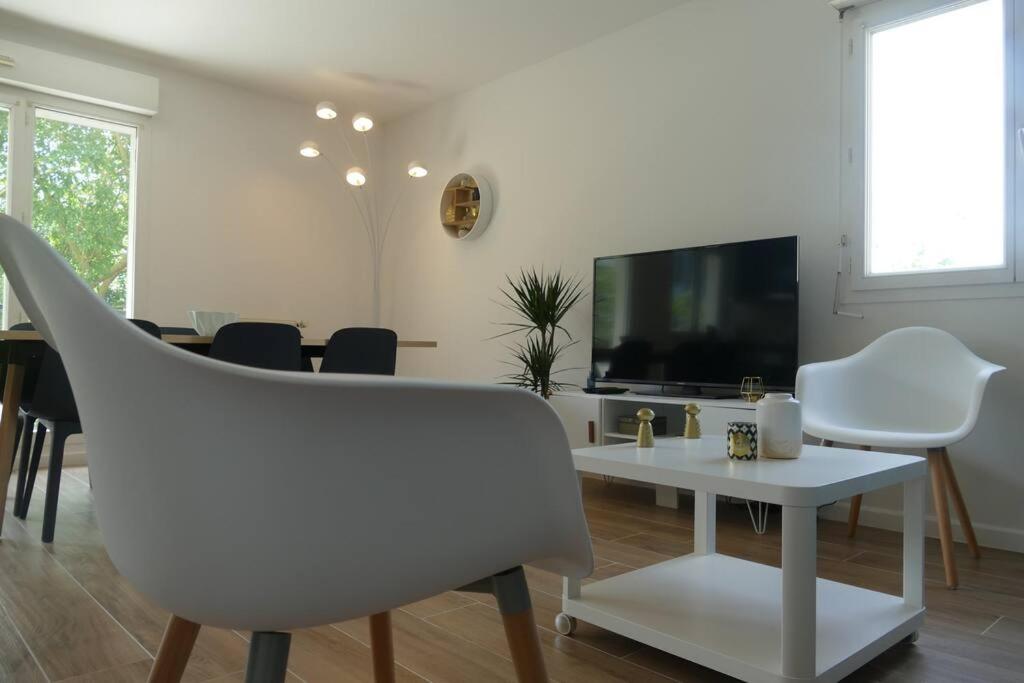 a living room with a tv and a table and chairs at Disneyland Paris, appartement 70m², parking privé in Serris