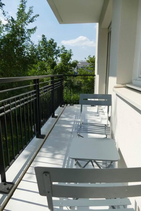 two chairs sitting on a balcony with a railing at Disneyland Paris, appartement 70m², parking privé in Serris