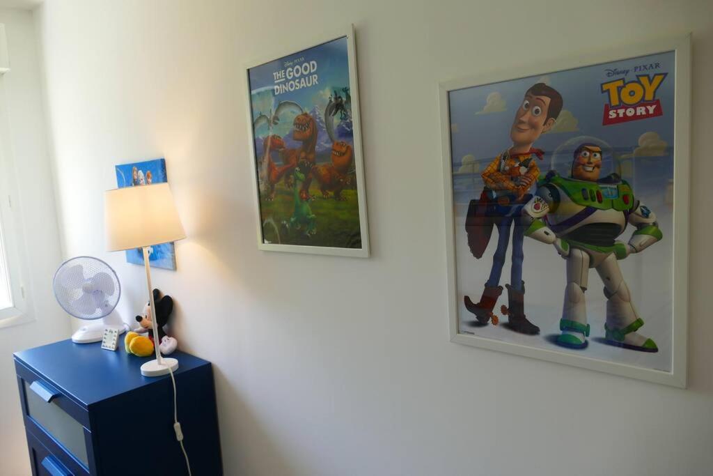 a room with two posters on the wall and a lamp at Disneyland Paris, appartement 70m², parking privé in Serris