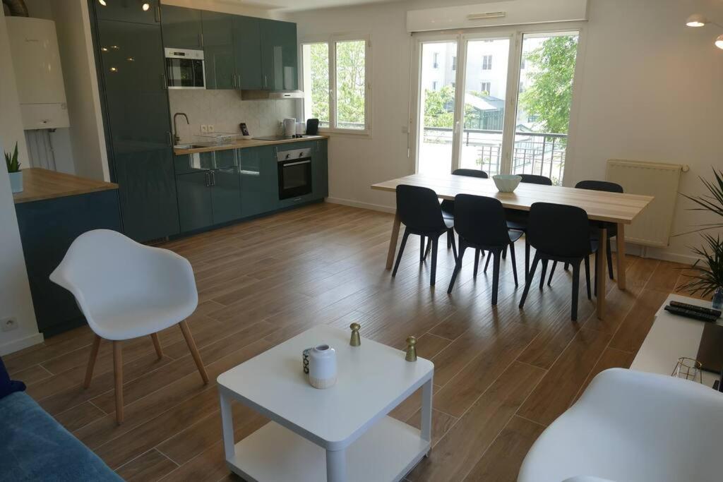 a kitchen and living room with a table and chairs at Disneyland Paris, appartement 70m², parking privé in Serris
