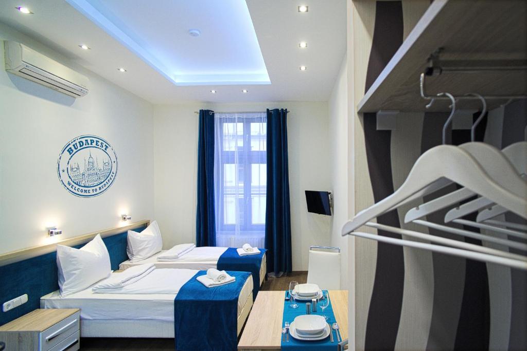 ブダペストにあるFocus Point Apartmentsのベッド2台とテーブルが備わるホテルルームです。